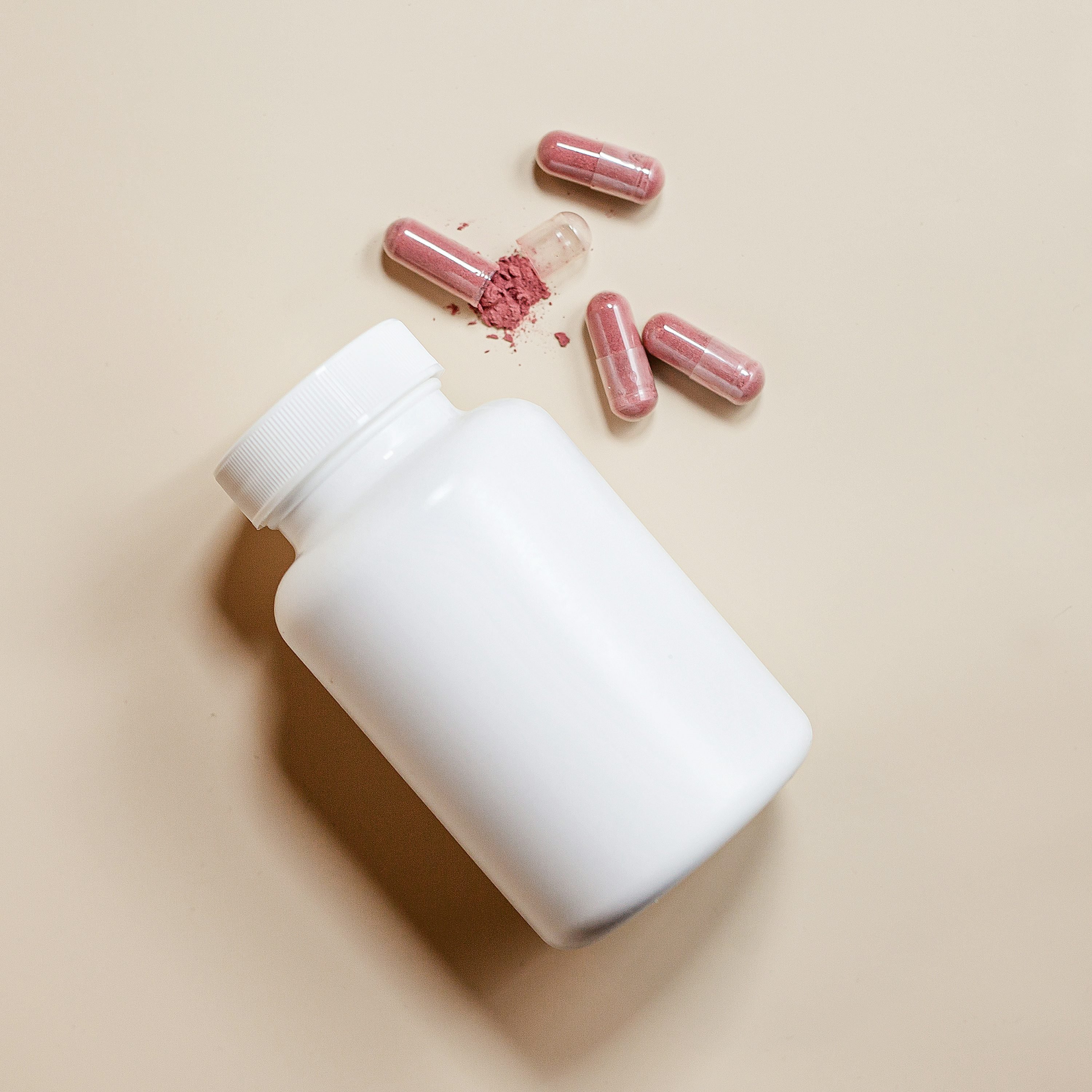 White bowl filled with assorted supplement pills placed on a table
