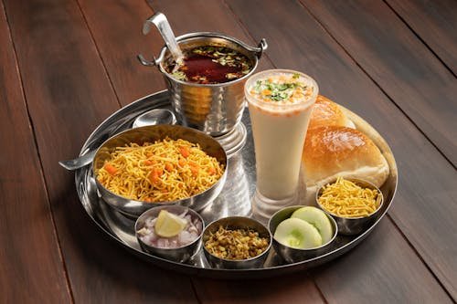 A balanced plate featuring Indian-style dishes with protein‑rich items such as lentils or chicken, accompanied by carbohydrate sources like rice or roti, presented on a tray as a suitable post‑workout meal.