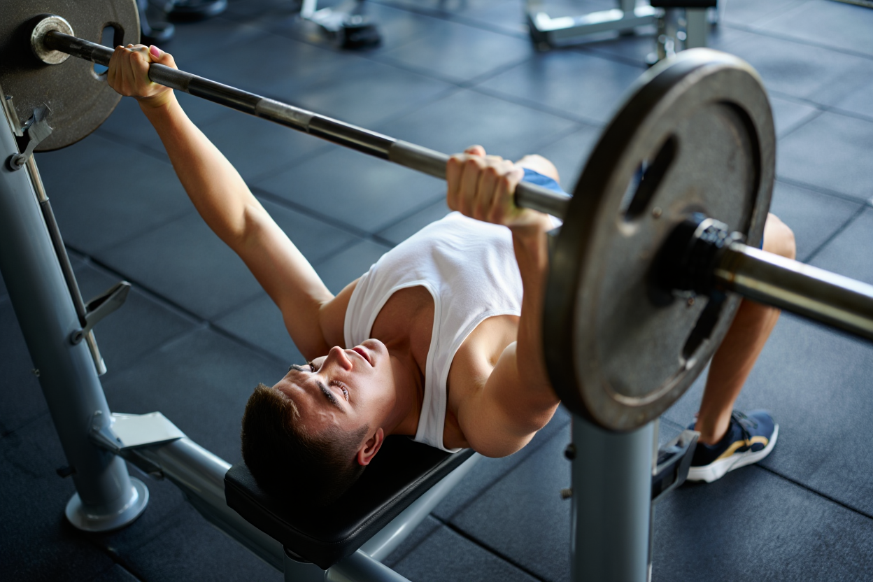 Un homme effectue un squat avec barre en salle de musculation