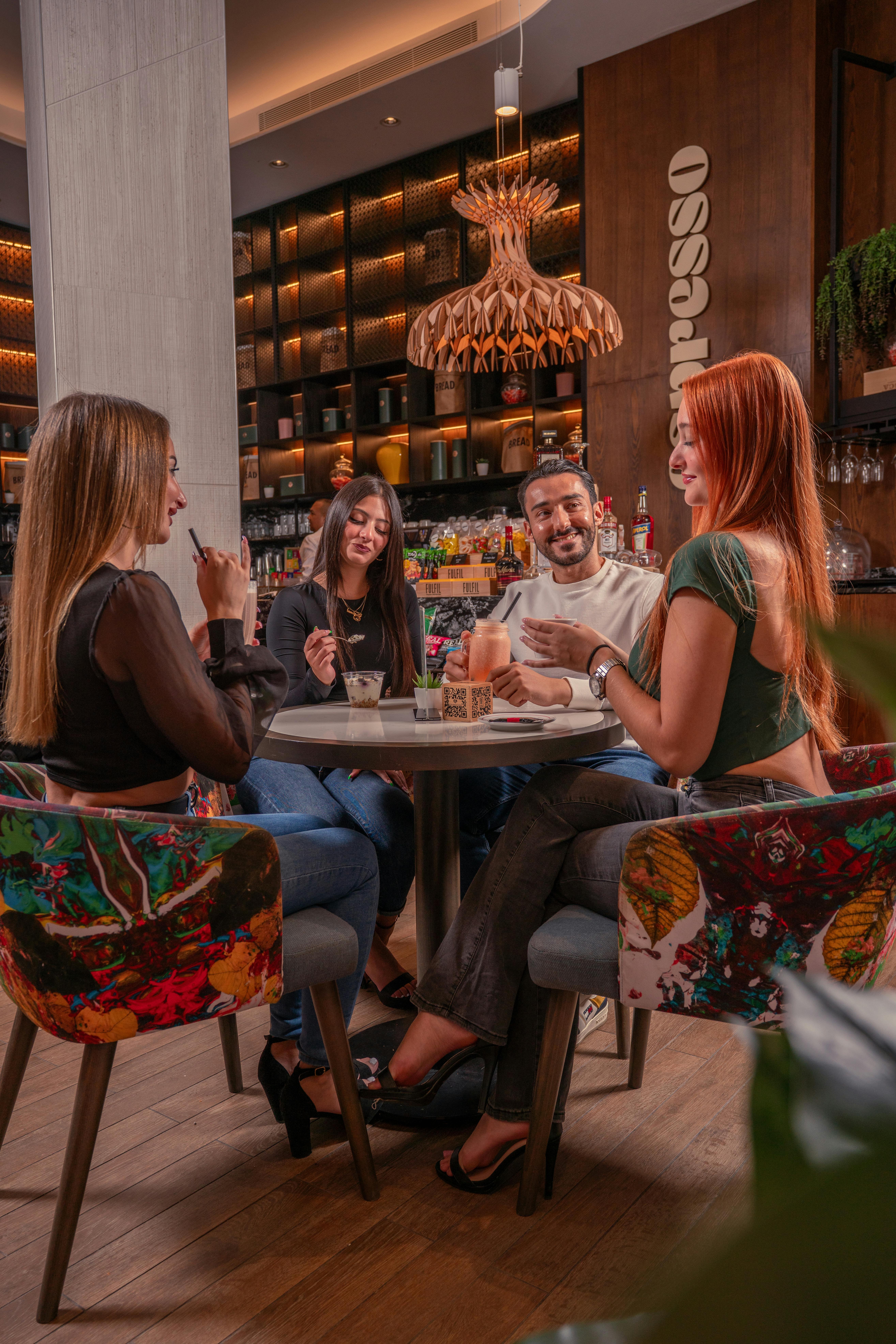 Indoor evening dinner scene at a table with a warm atmosphere, showing people enjoying Asian‑inspired dishes in a restaurant setting.