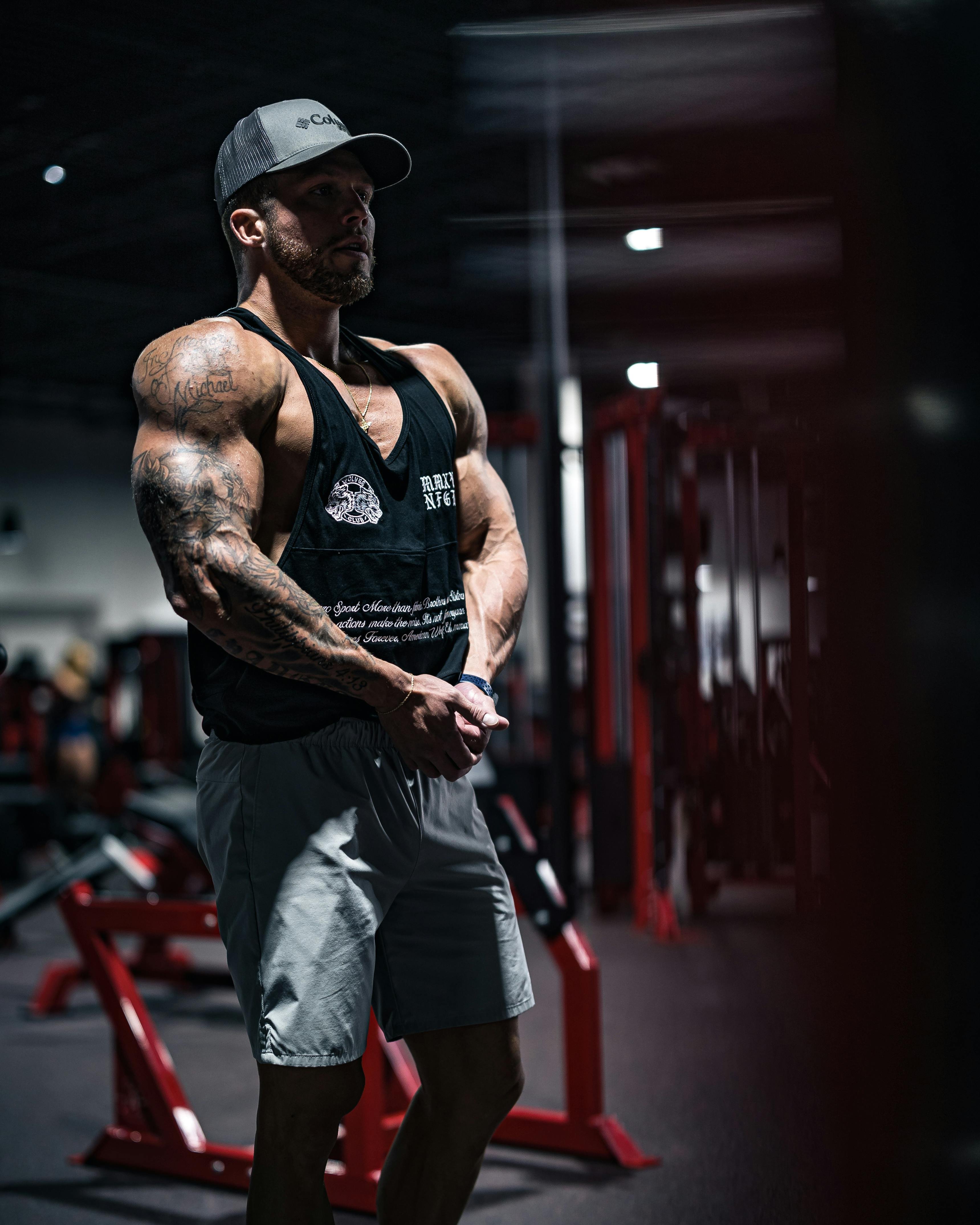 Man flexing his muscles in a gym, showcasing strength and muscle development