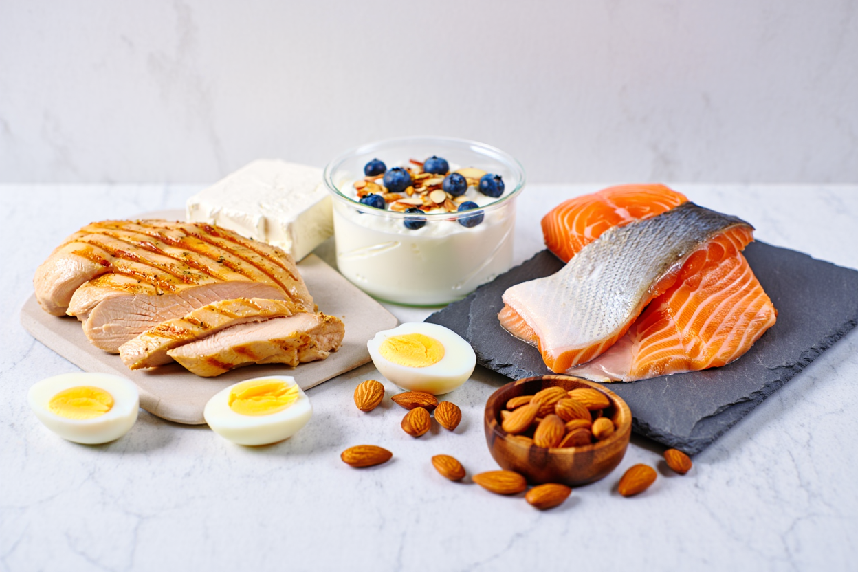 Variety of high-protein foods including eggs, chicken, fish, and dairy